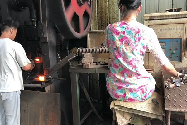 螺纹钢筋通过超音频大香蕉手机在线视频加热设备加热后 冲床锻压成螺母坯型